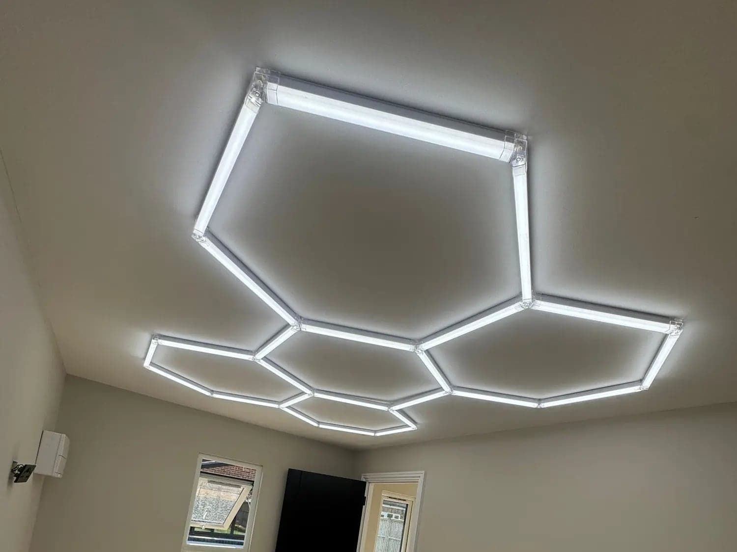 Garage workshop with a hexagon LED light grid across the ceiling